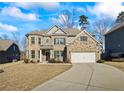 Beautiful brick home featuring manicured lawn, two-car garage and classic architectural details at 3330 Deaton Trl, Buford, GA 30519