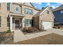 Inviting front entrance features a black front door with a seasonal wreath and manicured landscaping at 3330 Deaton Trl, Buford, GA 30519
