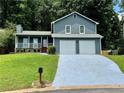 Traditional two-story home featuring a front porch, two car garage, and well kept lawn at 3945 Peninsula Ct, Lawrenceville, GA 30044