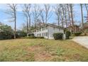 Side view of a two-story home showcasing its light brick exterior, trimmed hedges, and beautiful lawn at 2418 Brookdale Ne Dr, Atlanta, GA 30345