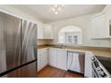 Modern kitchen featuring stainless steel appliances and white cabinetry at 3750 Magnolia Walk Trl, Cumming, GA 30040