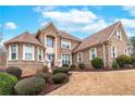 Gorgeous brick home highlighting meticulous landscaping, a circular driveway, and elegant architectural details at 3413 Talking Creek Ct, Conyers, GA 30094
