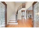 Grand foyer with hardwood floors, a staircase with iron railings, and an open view of the living spaces at 3413 Talking Creek Ct, Conyers, GA 30094
