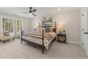 Well-lit bedroom featuring a four-poster bed, neutral walls, and large windows at 4529 Twinberry Dr, Powder Springs, GA 30127