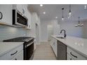 Modern kitchen with stainless steel appliances and light gray backsplash at 4529 Twinberry Dr, Powder Springs, GA 30127