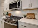 Modern kitchen features white cabinets, quartz countertops, and stainless steel appliances at 4529 Twinberry Dr, Powder Springs, GA 30127