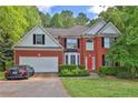 Beautiful two-story brick home with a well-manicured lawn and a bright red front door at 625 Piping Rock Pt, Lawrenceville, GA 30043
