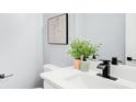 Modern bathroom features a white countertop, black faucet, and minimalist decor with a stylish house plant at 2170 Charleston Pl, Lithia Springs, GA 30122