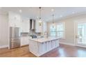 Bright kitchen featuring stainless steel appliances, hardwood floors, and a large center island at 324 Concord St, Alpharetta, GA 30009