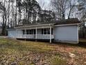 Light gray house with a lattice trimmed porch and white railings at 2755 Berry Rd, Loganville, GA 30052