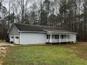 Exterior elevation of light gray house with 2-car garage and covered front porch at 2755 Berry Rd, Loganville, GA 30052