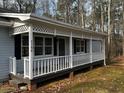 Close up of covered front porch with white rails and lattice detail at 2755 Berry Rd, Loganville, GA 30052