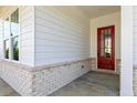 Inviting front porch with brick accents, white columns, wood door, and large windows providing ample natural light at 128 Kingsley Way, Acworth, GA 30102