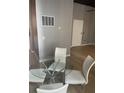 Glass dining table with four white chairs at 20 Marietta Nw St # 13F, Atlanta, GA 30303