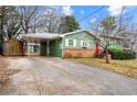 Charming home featuring a covered carport, red front door, and brick accents at 282 Evelyn Nw St, Marietta, GA 30064