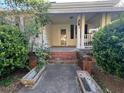 Traditional home's inviting front porch with brick steps and concrete walkways at 5121 Newark Ave, Clarkdale, GA 30111