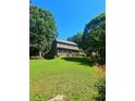 Expansive backyard featuring a large lawn, mature trees and garden at 4449 Inns Brook Dr, Snellville, GA 30039