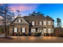 Two-story brick home with a large front yard and landscaping at dusk at 4504 Sterling Pointe Nw Dr, Kennesaw, GA 30152