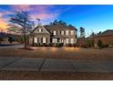 Two-story brick home with a large front yard, driveway, and sidewalk at dusk at 4504 Sterling Pointe Nw Dr, Kennesaw, GA 30152