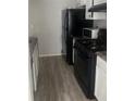 Small kitchen with black appliances and granite countertops at 2511 Pine Tree Trl, Atlanta, GA 30349