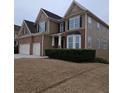 Two story house with a three car garage and mature shrubs at 7413 Melhana Ln, Union City, GA 30291