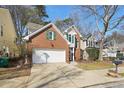 Two-story brick home with garage and driveway, featuring manicured front lawn at 485 Kensington Parc Dr, Avondale Estates, GA 30002