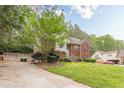 Side view of charming two-story brick home with lush greenery at 4671 W Lake Se Dr, Conyers, GA 30094
