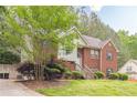 Side view of charming two-story brick home with lush greenery at 4671 W Lake Se Dr, Conyers, GA 30094
