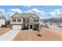 Charming two-story home with brick and stone exterior, manicured lawn, and attached two-car garage at 7710 Tiberon Pkwy, Cumming, GA 30028