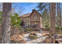 Wooded backyard featuring a fire pit area and deck with hot tub at 96 Grand Ave, Suwanee, GA 30024