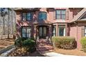 Close up of brick home featuring a stylish front door and manicured greenery at 96 Grand Ave, Suwanee, GA 30024