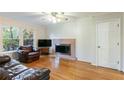 Living room with hardwood floors, fireplace, and a ceiling fan at 620 Oakstone Way, Roswell, GA 30075