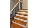 Modern staircase featuring wooden treads and striking black metal railings, adding elegance to the home's interior at 620 Oakstone Way, Roswell, GA 30075