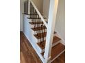 Modern staircase with wooden steps, white risers, and sleek black metal railings at 620 Oakstone Way, Roswell, GA 30075