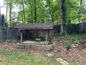 Backyard with a wooden gazebo, stone-lined flower beds, and a wooden fence at 4876 Velva Nw Way, Lilburn, GA 30047