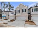 Beautiful townhome exteriors featuring neutral siding, brick bases, and one-car garages, set in a modern design at 320 Shine Dr, Stockbridge, GA 30281