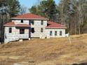 View of two-story home with red roof in construction phase and covered with protective wrap at 515 Penny Ln, Loganville, GA 30052