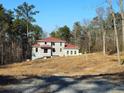 View of two-story home with red roof in construction phase on a large lot at 515 Penny Ln, Loganville, GA 30052