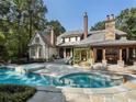 Luxury home featuring backyard pool, outdoor fireplace, and lush landscaping at 4345 Mount Paran Nw Pkwy, Atlanta, GA 30327