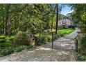 Stone pillars frame a gated entrance and winding driveway leading to the house at 4345 Mount Paran Nw Pkwy, Atlanta, GA 30327