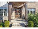 Elegant front entry with double doors, stone flooring, and large, decorative wreaths at 4851 Hanalei Holw, Suwanee, GA 30024