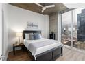 Modern bedroom features a city view from a large window and streamlined furnishings at 855 Peachtree Ne St # 1508, Atlanta, GA 30308