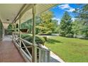 Inviting covered front porch with white railings overlooking a lush, green lawn and mature trees at 2144 Kennesaw Due West Nw Rd, Kennesaw, GA 30152