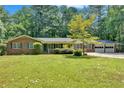 Charming brick home with a spacious front yard, mature trees, a two car garage, and ample parking at 2144 Kennesaw Due West Nw Rd, Kennesaw, GA 30152