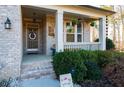 Brick front porch with wooden bench, hanging planters, and a welcome sign at 423 Payne Rd, Woodstock, GA 30188