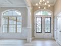 Inviting foyer with decorative glass double doors, chandelier, and expansive windows showcasing the home's exterior at 2106 Lacroix Way, Conyers, GA 30094