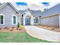Charming brick home with a walkway leading to a covered entrance and professionally landscaped flowerbeds at 2106 Lacroix Way, Conyers, GA 30094