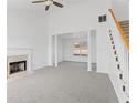 Living room features an open-concept design, fireplace, gray carpet, stairs with wood railing at 5728 Rock Shoals Way, Atlanta, GA 30349