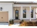 Front entry with dark gray door and brick steps leading to a covered porch at 210 Idylwilde Way, Canton, GA 30115