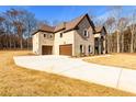 Attractive brick home featuring a two-car garage, concrete driveway, and mature landscaping at 2571 Se Ebenezer Rd, Conyers, GA 30094